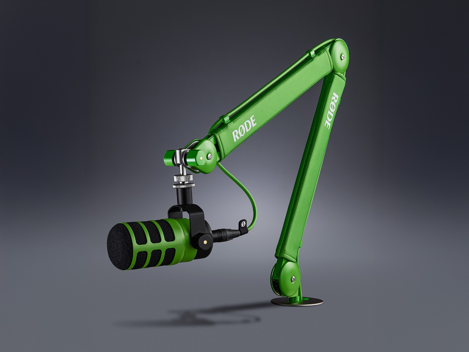 Green RØDE PSA1+ arm with a microphone in a modern studio